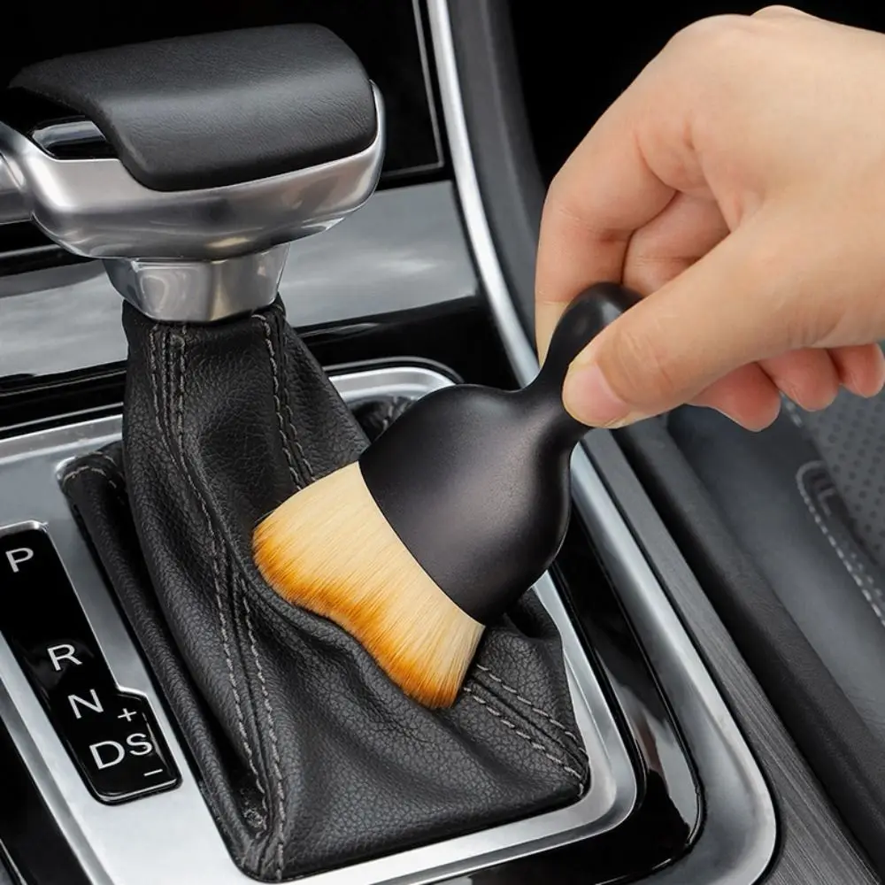 Cleaning center console and tight spaces with curved detailing brush
